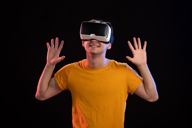 Porträt eines jungen Mannes mit VR-Headset an der dunklen Wand