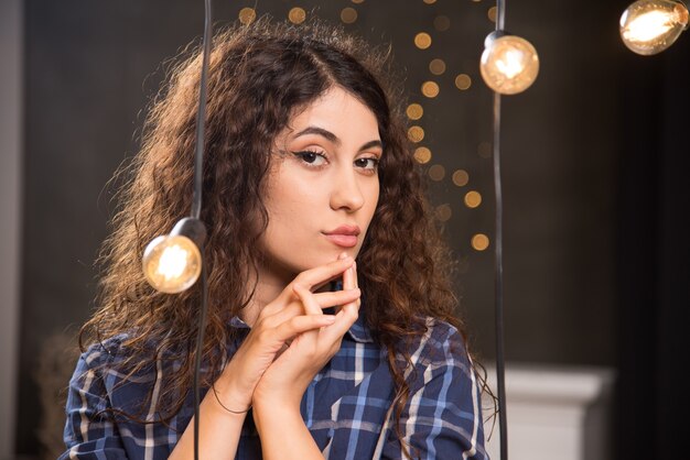 Porträt eines jungen Models im karierten Hemd, das in der Nähe von Lampen posiert