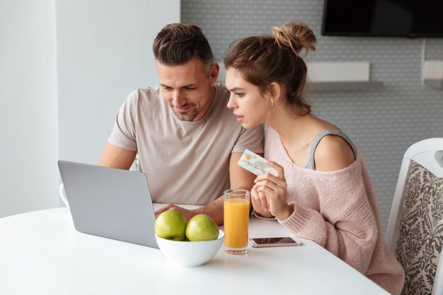 Porträt eines jungen Paares, das online mit Laptop kauft