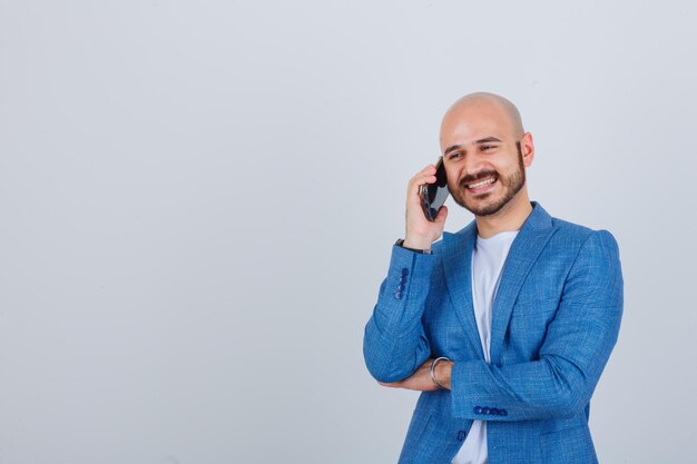 Porträt eines jungen selbstbewussten Mannes, der am Telefon spricht