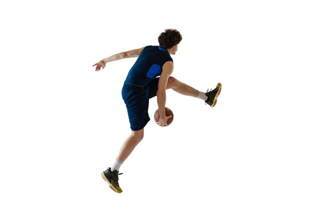 Porträt eines jungen sportlichen Jungen, der Trainingsbasketball spielt, isoliert über weißem Studiohintergrund Seitenansicht
