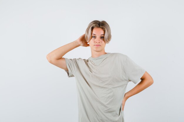 Porträt eines jungen Teenagers, der die Hand im T-Shirt hinter dem Kopf hält und selbstbewusste Vorderansicht schaut