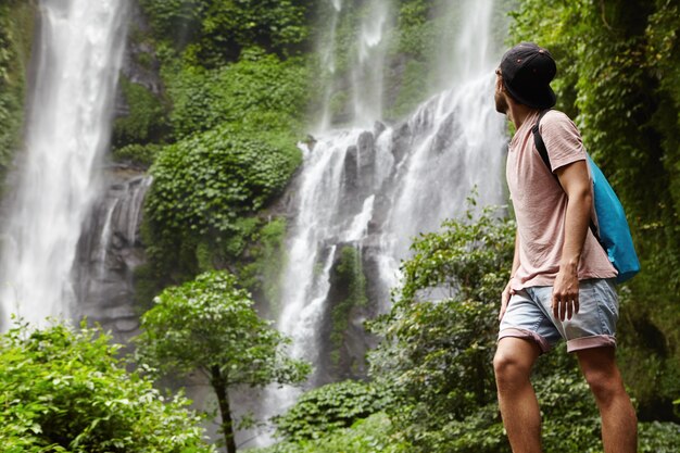 Porträt eines jungen Wanderers oder Abenteurers in Jeansshorts und Hysteresen, die die Natur genießen