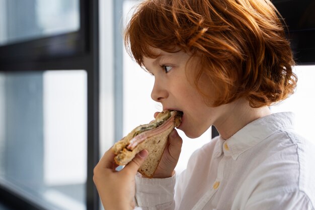 Porträt eines Kindes, das in der Schule Sandwich isst