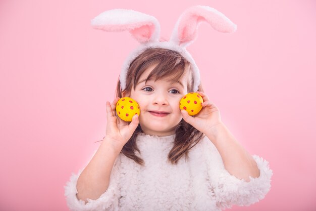 Porträt eines kleinen Mädchens mit Hasenohren mit Ostereiern