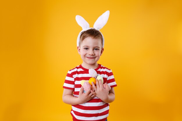 Porträt eines lächelnden entzückenden kleinen Jungen, der Hasenohren trägt