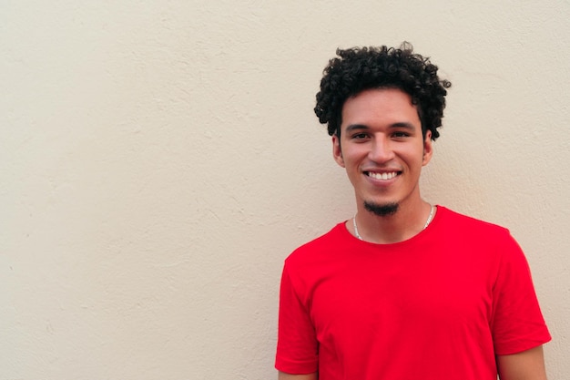 Porträt eines lächelnden jungen mannes, der ein rotes t-shirt trägt