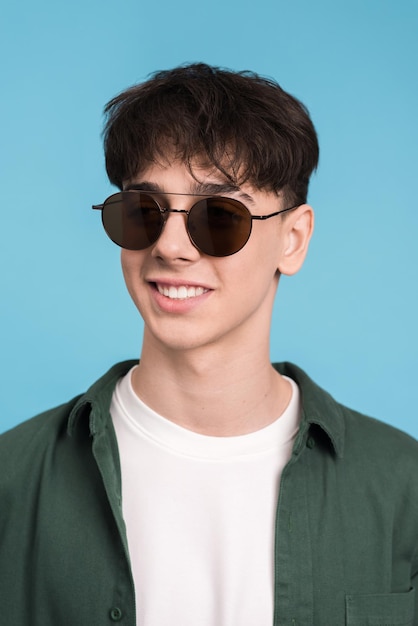 Kostenloses Foto porträt eines lächelnden jungen mannes in der sonnenbrille