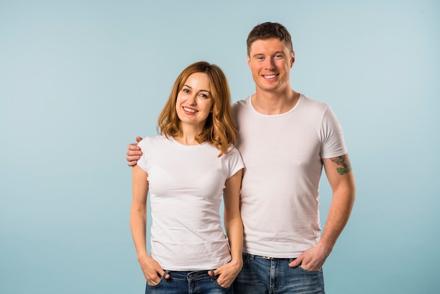 Porträt eines lächelnden jungen Paares gegen blauen Hintergrund