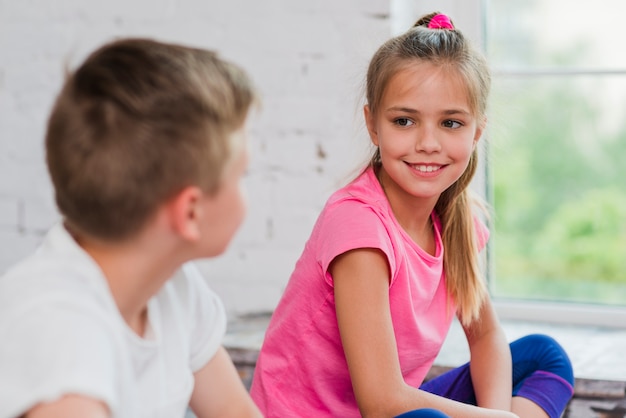 Kostenloses Foto porträt eines lächelnden mädchens, das jungen betrachtet