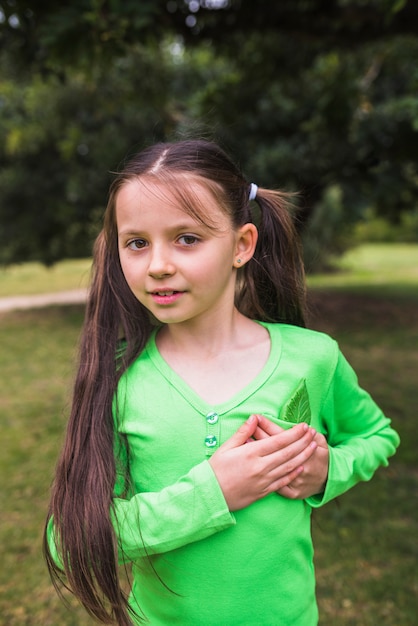 Porträt eines Mädchens mit gefälschtem grünem Blatt in ihrer Tasche