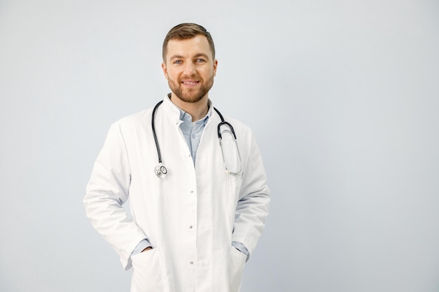 Porträt eines männlichen Arztes, der die Kamera isoliert auf weißem Hintergrund betrachtet