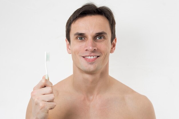 Porträt eines Mannes, der eine Zahnbürste hält