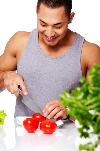 Porträt eines Mannes im grauen Hemd, der Tomaten essen wird