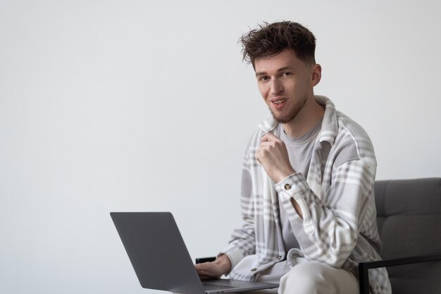 Porträt eines Mannes mit Laptop-Computer auf grauem Hintergrund