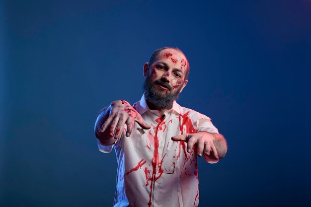 Porträt eines menschlichen Zombies mit Kratzern und finsteren Wunden, die vor der Kamera posieren, gefährliche untote Leiche mit gruseligen Narben und gruseligem Gesicht im Studio. Doomsday grausamer Monsterteufel.
