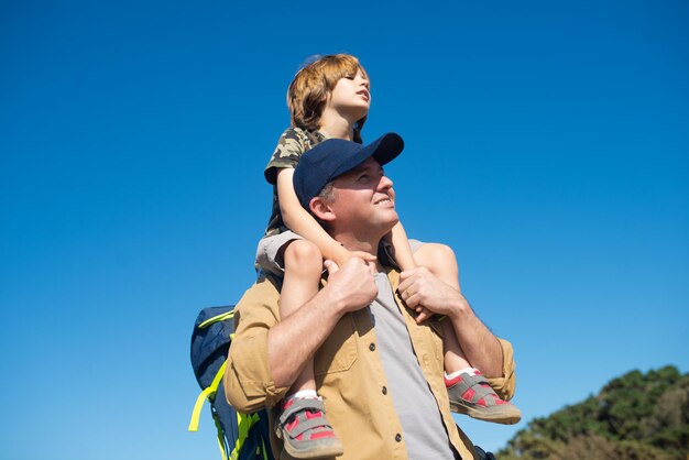 Porträt eines mittleren erwachsenen Mannes mit Sohn huckepack