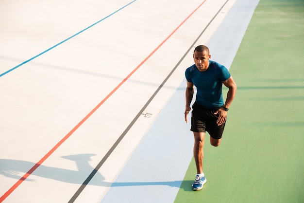 Porträt eines muskulösen Sportlers in voller Länge, der läuft
