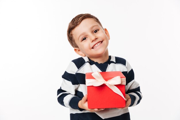 Porträt eines reizenden niedlichen kleinen Kindes, das Geschenkbox hält