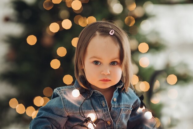 Porträt eines schönen kleinen Mädchens in der Neujahrsatmosphäre