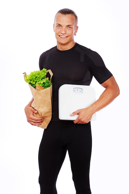 Porträt eines sexy Mannes, der im Studio mit Gemüse posiert