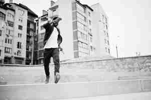 Kostenloses Foto porträt eines springenden stylischen afroamerikanischen mannes auf sportswear-mütze und brille schwarze männer emotion model street fashion