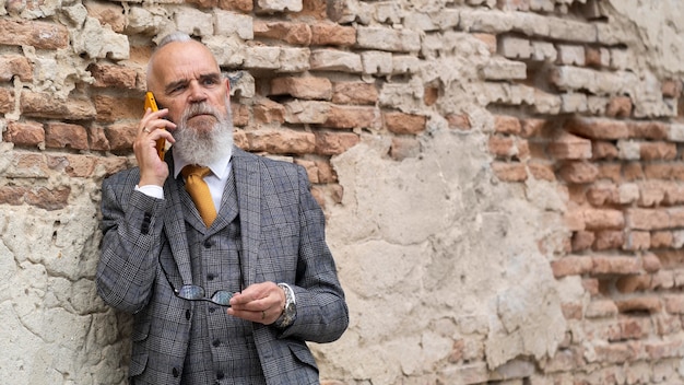 Porträt eines stilvollen älteren Mannes auf seinem Telefon his