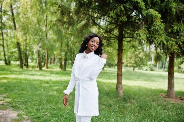 Porträt eines stilvollen schwarzen afroamerikanischen Mädchens, das im grünen Park bleibt