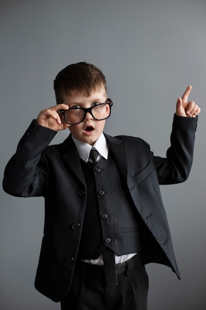 Porträt eines süßen Jungen mit Anzug und Brille