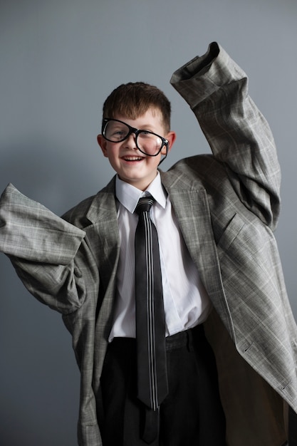 Porträt eines süßen Kindes mit übergroßem Anzug und Brille