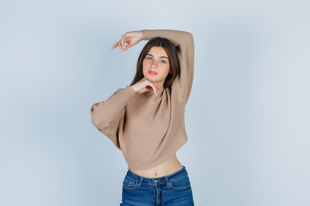 Porträt eines Teenager-Mädchens, das Mode in Pullover, Jeans und zarter Vorderansicht macht