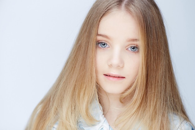 Porträt eines Teenager-Mädchens mit langen blonden Haaren und blauen Augen.