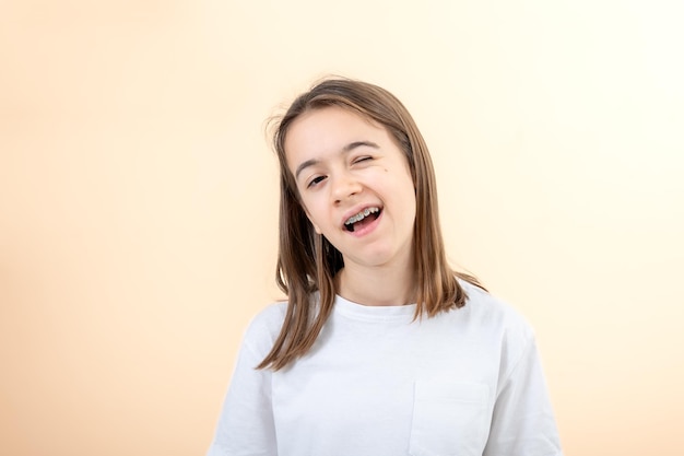 Kostenloses Foto porträt eines teenagermädchens, das fröhlich auf einem gelben hintergrund blickt