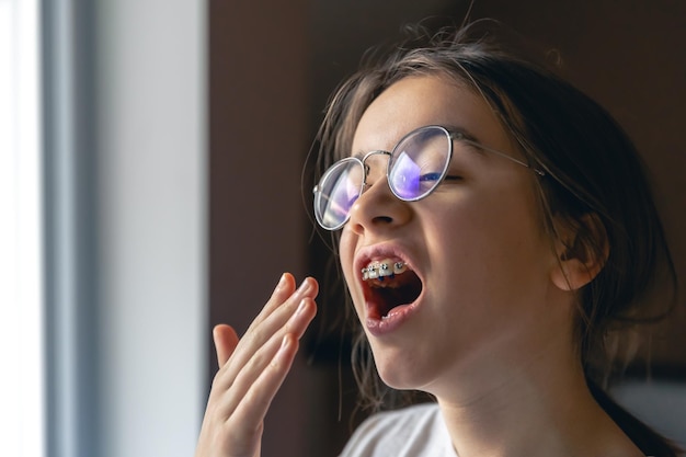 Kostenloses Foto porträt eines teenagermädchens mit brille und zahnspange