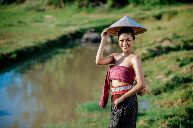 Porträt junge asiatische Frau in schöner thailändischer traditioneller Kleidung am Reisfeld