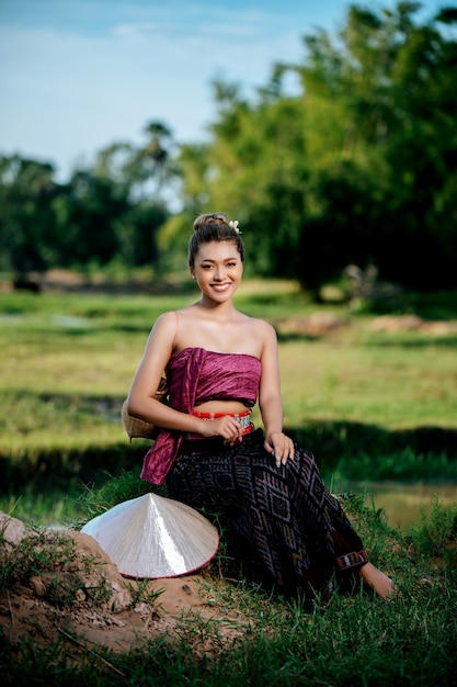 Porträt junge asiatische Frau in schöner thailändischer traditioneller Kleidung am Reisfeld