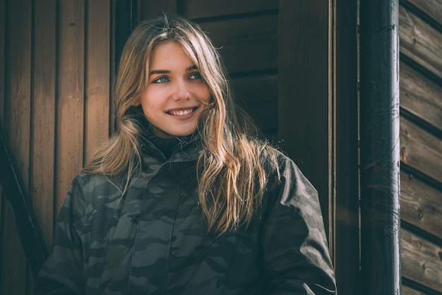 Porträt Junge hübsche Frau im Winter in einem Blockhaus im Schnee