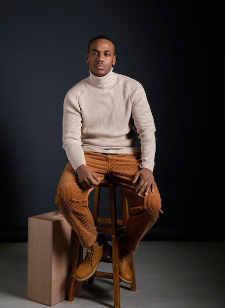 Porträt junger afrikanischer Mann, der auf Stuhl sitzt