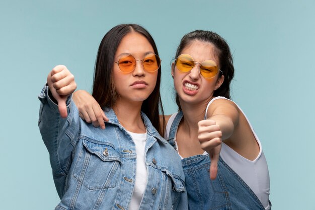 Porträt junger Mädchen im Teenageralter mit Sonnenbrille, die Daumen nach unten zeigt