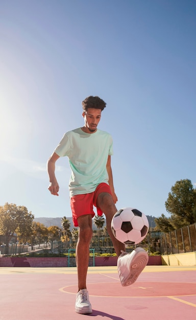 Porträt junger Mann, der Fußball spielt