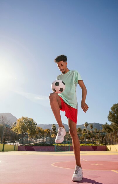 Porträt junger Mann, der Fußball spielt