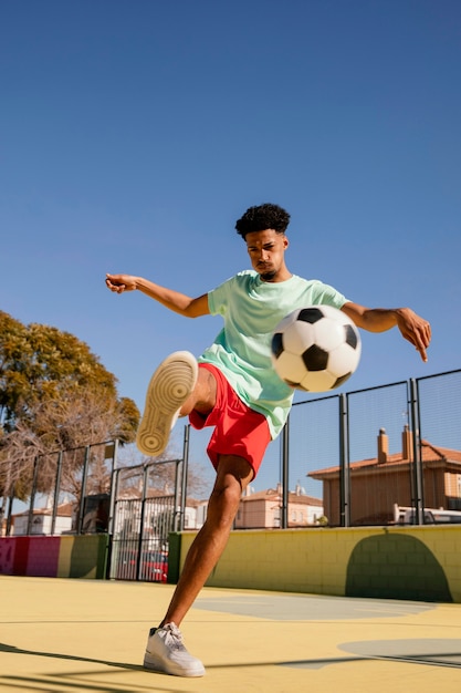 Porträt junger Mann, der Fußball spielt