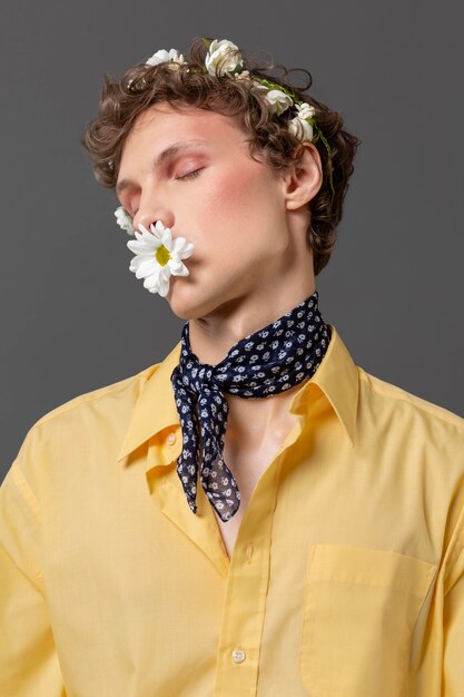 Porträt junger Mann, der mit Blumenkranz aufwirft