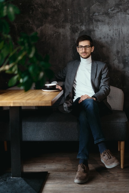 Porträt junger, selbstbewusster Geschäftsmann, der Brille trägt