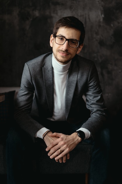 Porträt junger, selbstbewusster Geschäftsmann, der Brille trägt