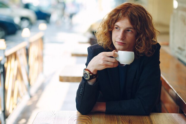 Porträt modischer rötlicher Mann, der Kaffee trinkt