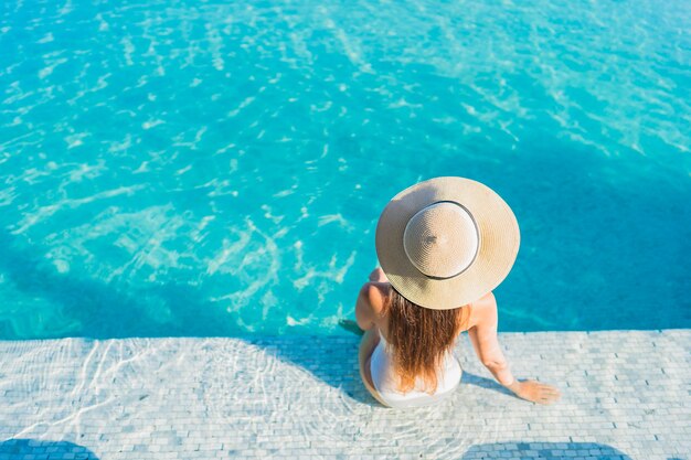 Porträt schöne junge asiatische Frau, die sich um Freibad mit Blick auf die Stadt entspannt