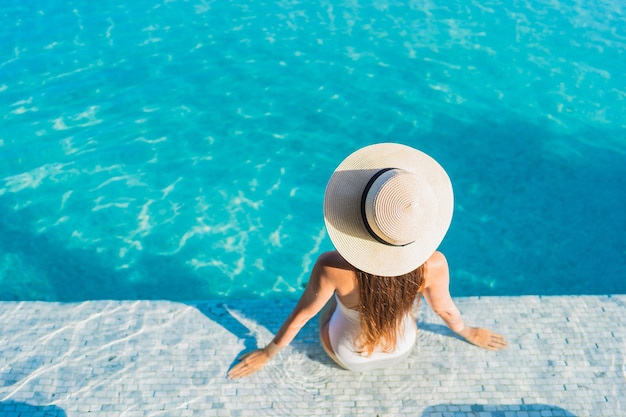 Porträt schöne junge asiatische Frau, die sich um Freibad mit Blick auf die Stadt entspannt