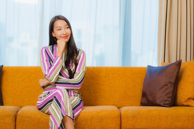Porträt schöne junge asiatische Frau entspannen auf Sofa im Wohnzimmer Interieur