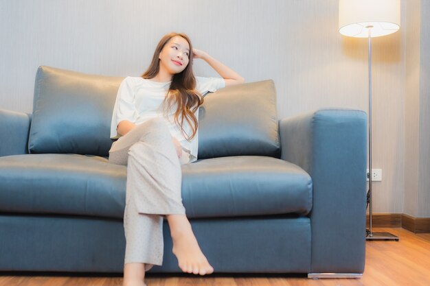 Porträt schöne junge asiatische Frau entspannen auf Sofa im Wohnzimmer Interieur